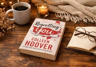 Regretting You book by Colleen Hoover placed on wooden table with coffee in cozy reading setup